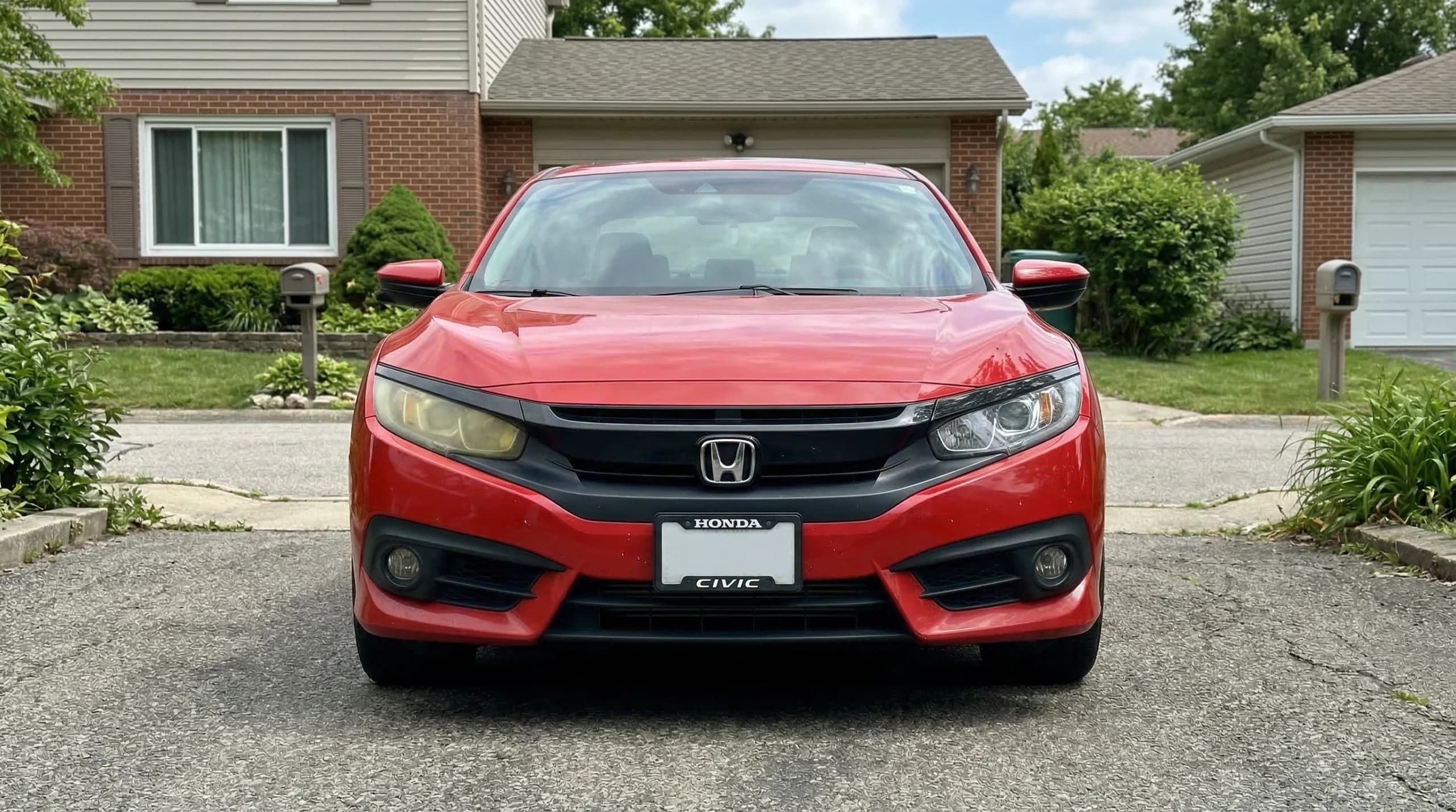 Red car parked in front of a house.
