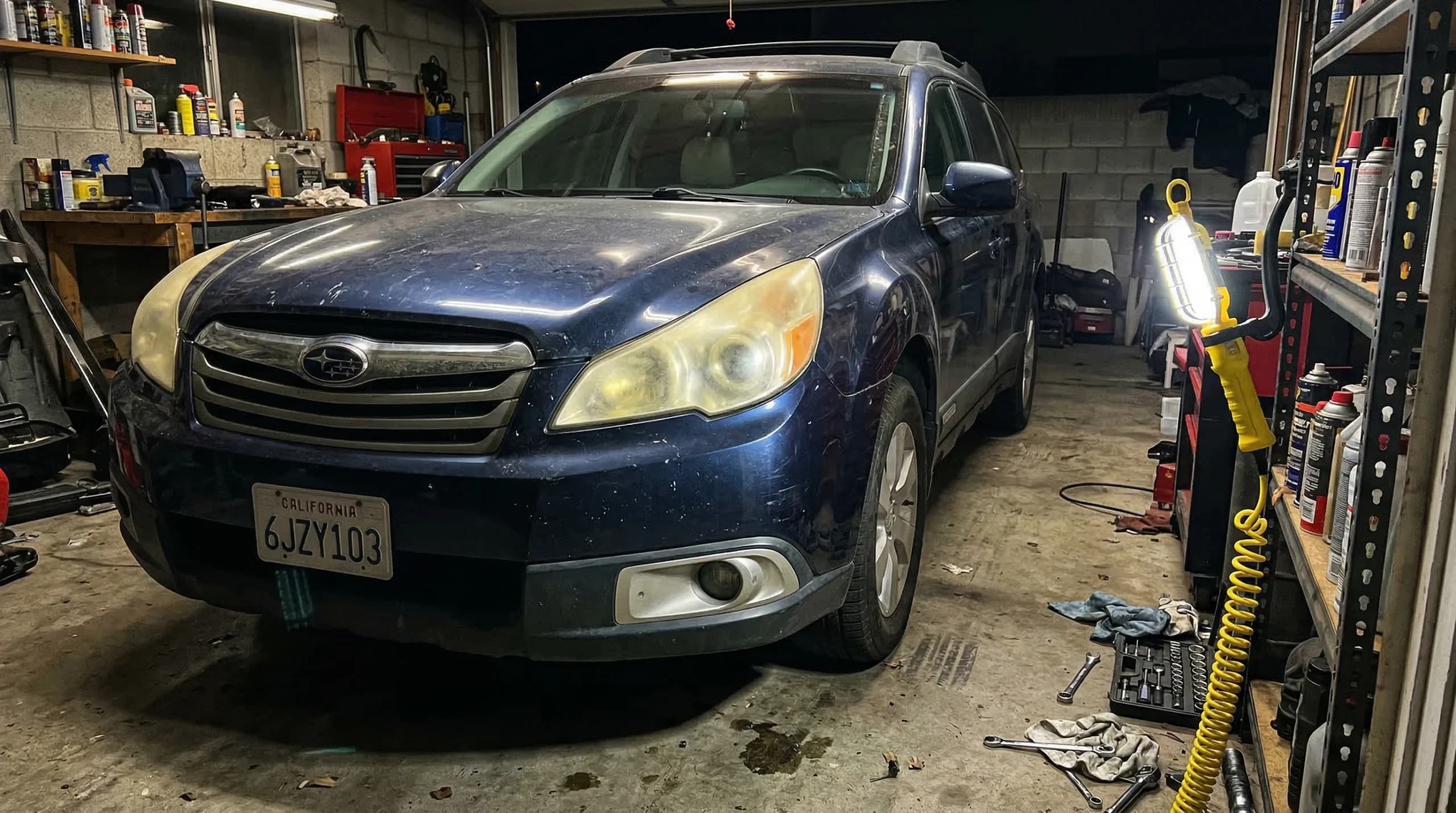Blue car in a cluttered garage